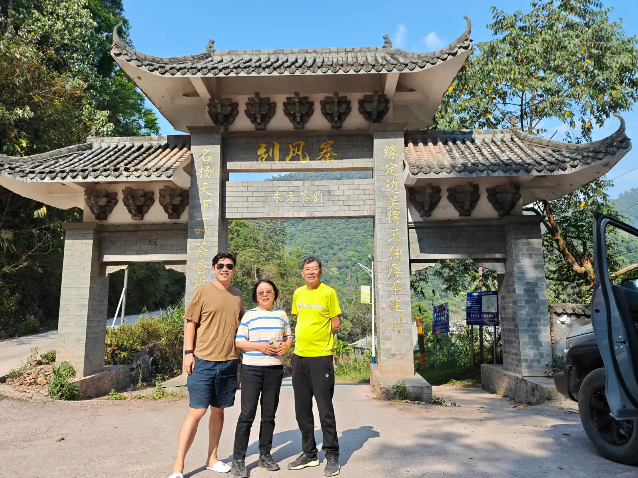 Three travellers standing beneath the gate of Guafengzhai village